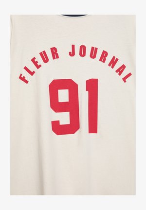 Red text "FLEUR JOURNAL" curved above the large number "91" printed on a light cream fabric background.