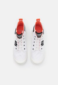 Sneakers in tela bianca con accenti neri, linguetta arancione, punta tondeggiante e suola in gomma bianca. Presentano un'etichetta nera e lacci neri.