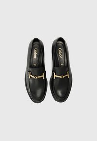 Mocassins en cuir noir avec un accent en métal doré à l'avant. Texture lisse avec des détails de couture. Bout arrondi et semelle plate.