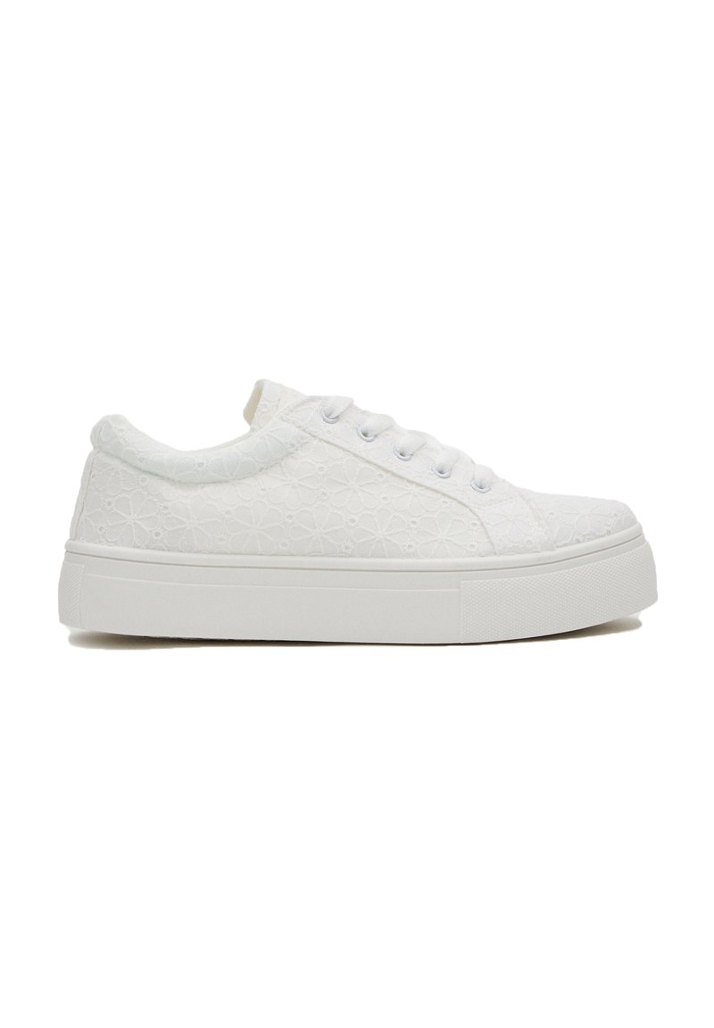 Zapatillas blancas con patrón floral, parte superior texturizada, punta redonda, cierre de cordones y suela de goma blanca gruesa.