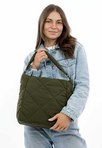 Quiltet olivengrøn tote taske med kort håndtag og kædeaccent, der har en rektangulær form og blødt, tekstureret stof.
