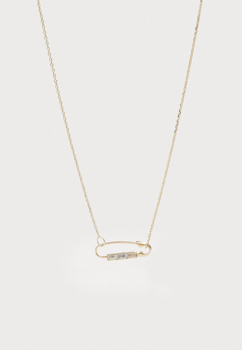 Zelta krāsas ķēdes kaklarota ar drošības adatas dizainu, kurā ir trīs mazi, caurspīdīgi dārgakmeņi, kas izvietoti horizontālā līnijā.