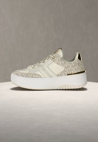 Bela superga z bež vzorcem logotipa MK, gladkim usnjem in tekstilnim zgornjim delom, zlato obrobo ter debelim belim gumijastim podplatom.