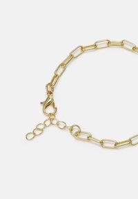 Bracelete de corrente de ouro com elos alongados, fecho de lagosta e extensão de corrente texturizada para ajuste de comprimento.