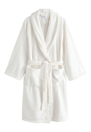 Biały szlafrok o strukturze waflowej, z kołnierzem typu szalowego, długimi rękawami, dwoma przednimi kieszeniami oraz paskiem z tkaniny związanym w talii.