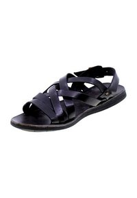 Sandalo in pelle nera con cinturini incrociati, design con punta aperta e suola piatta con superficie leggermente texture. Include una cinghia regolabile per la caviglia.
