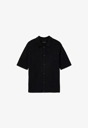 Sort kortærmet strikket skjorte med knapper og krave, med et tekstureret hjerte- og geometrisk mønster over hele stoffet.
