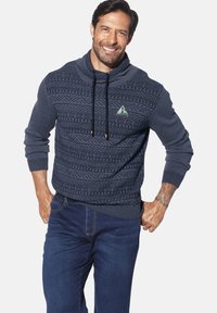 Marineblauer Strickpullover mit strukturiertem Muster, hohem Kragen und Kordelzügen. Verfügt über ein dreieckiges Logo-Label sowie gerippte Bündchen und Säume.