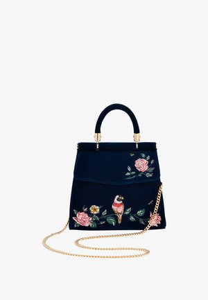 Navy velvet handbag with gold chain strap, featuring embroidered roses and a parrot design; structured shape and top handle.