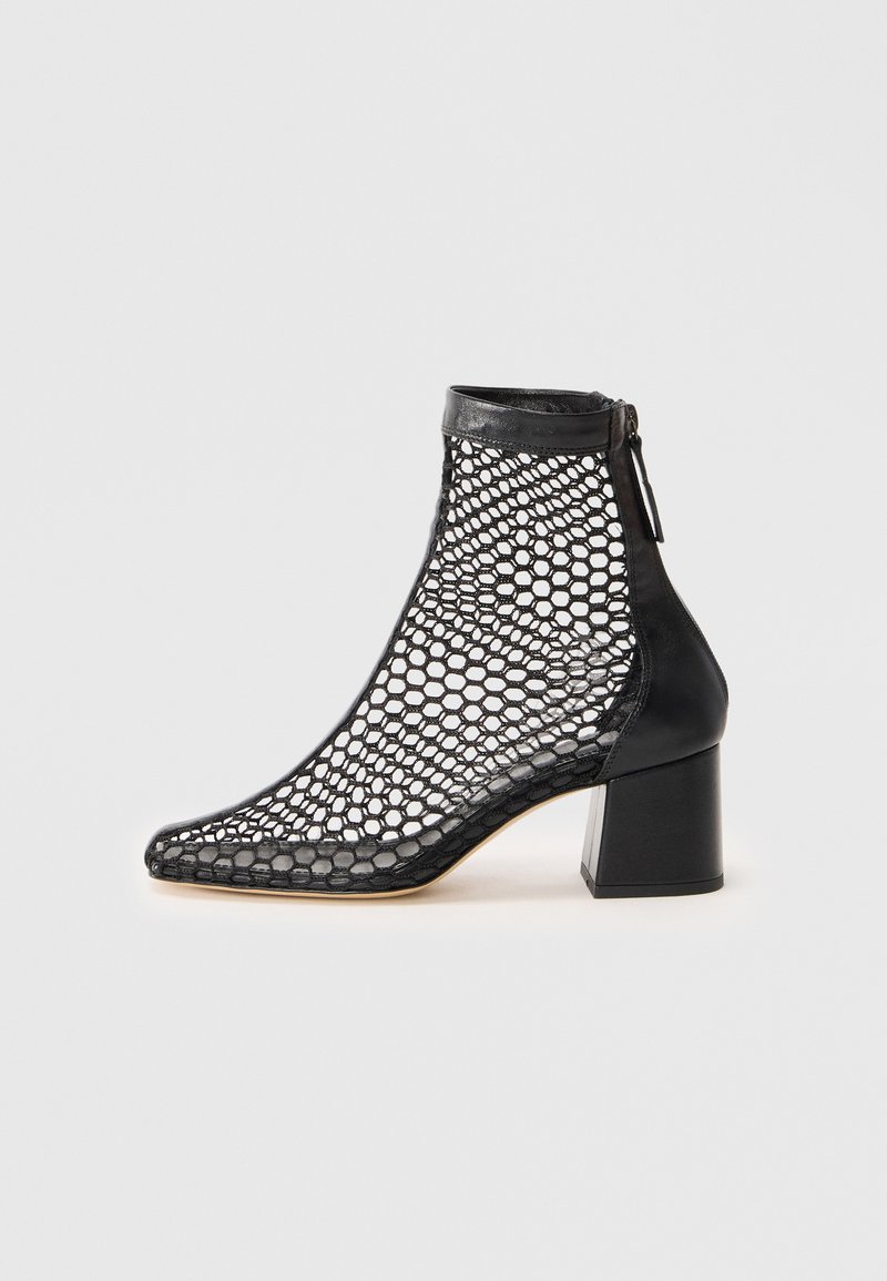 Botine negre până la gleznă, cu un upper din plasă hexagonală, toc solid, capac de piele pe vârf și închidere cu fermoar la spate.