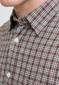 Camisa de cuadros roja y negra de botón con cuello, con una tela texturizada y un bolsillo en la parte frontal.