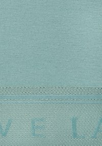 Ein strukturiertes, hellblaues Gewebe mit einer glatten oberen Schicht und einem gerippten Muster sowie einer kontrastierenden, netzartigen unteren Kante.