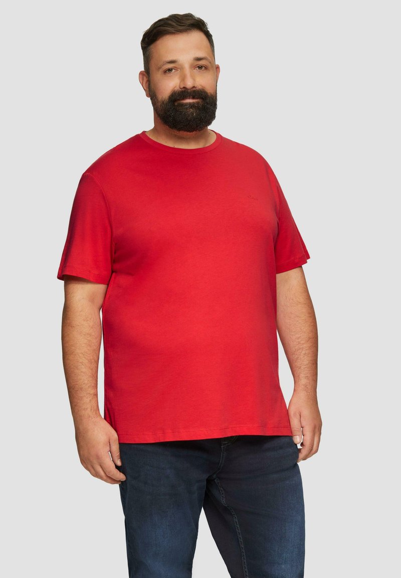 Rode katoenen T-shirt met korte mouwen, ronde hals en een ontspannen pasvorm. Draag gecombineerd met donkere spijkerbroeken. Eenvoudig ontwerp, zachte textuur.