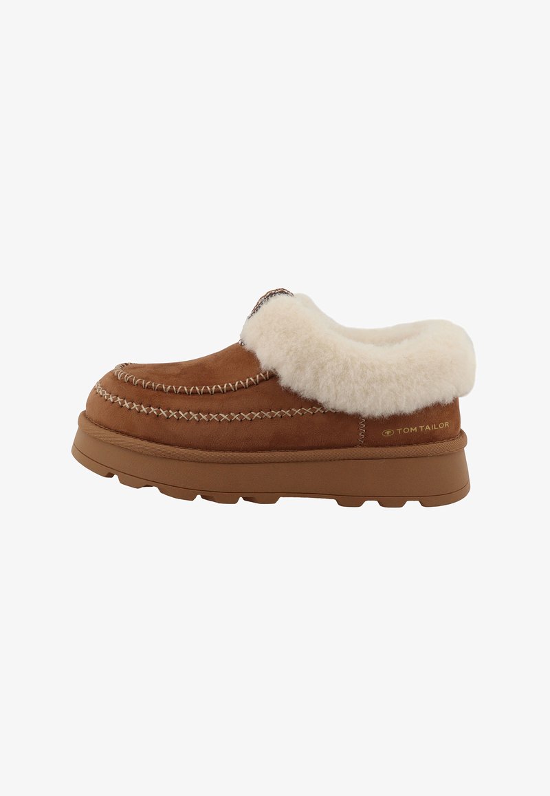 Chaussure marron en daim à enfiler avec une semelle épaisse en caoutchouc, une doublure de col blanche et duveteuse, et des coutures décoratives le long du bord supérieur.