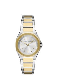 Osmiboké hodinky s stříbrným ciferníkem, zlatými akcenty a dvoutónovým kovovým páskem. Mají minimální značky a krystalové ozdoby.