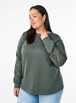 Olive green sweatshirt with long sleeves featuring intricate embroidery on the sleeves and a relaxed fit. Soft, textured fabric.