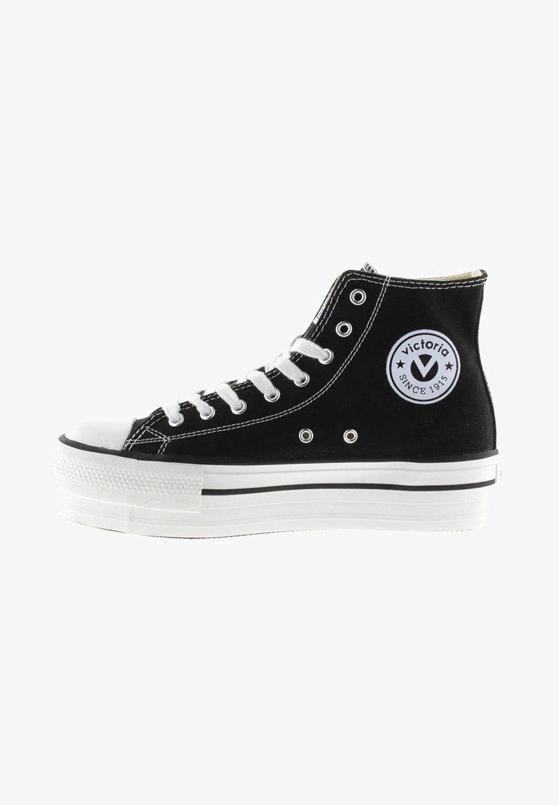 Baskets montantes noires en toile, avec un embout blanc et des lacets blancs, ornées d'un patch logo rond et d'une semelle plateforme blanche en superposition.