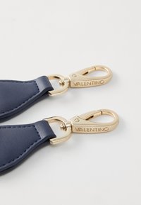 Bracelet en cuir bleu marine avec quincaillerie dorée. Présente un fermoir avec "VALENTINO" gravé. Texture lisse et bords cousus.