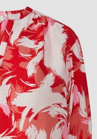 Rode en roze abstracte blouse met bloemenpatroon van lichtgewicht stof, ronde halslijn en een ontspannen pasvorm; heeft een zachte, vloeiende textuur.