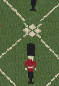 Dzianina z zielonym tłem i białymi wzorami w diamenty. Całość pokryta powtarzającymi się figurkami w czerwono-czarnych uniformach królewskiej guardii.