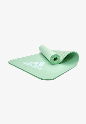 Green yoga mat made of textured rubber, with a smooth finish and rounded edges. Features a white adidas logo near the bottom.