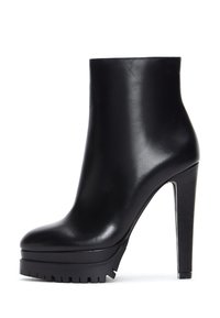 Zwarte leren enkellaars met een hoge stilettohak, platformbasis en gestructureerde rubberen zool. Elegant, afgerond te ontwerp.