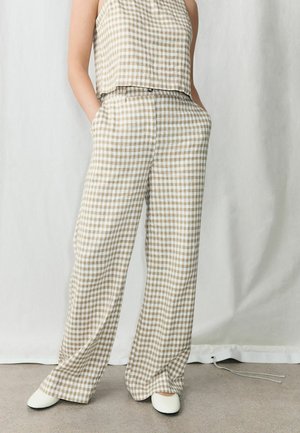 Pantaloni cu croială largă, bej și alb cu model în carouri gingham, cu croială lejeră și buzunare. Asortați cu un top scurt asortat, având un model similar.