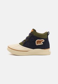 Schoenen met marineblauw en olijfgroen suede en een crèmekleurige neuskap. Inclusief een berenpatch en gestreepte veters, met een geribbelde zool.