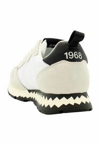 Sneaker grigia e bianca con una tomaia in suede e mesh, caratterizzata da un tallone nero contrassegnato "1968" e una suola in gomma seghettata.