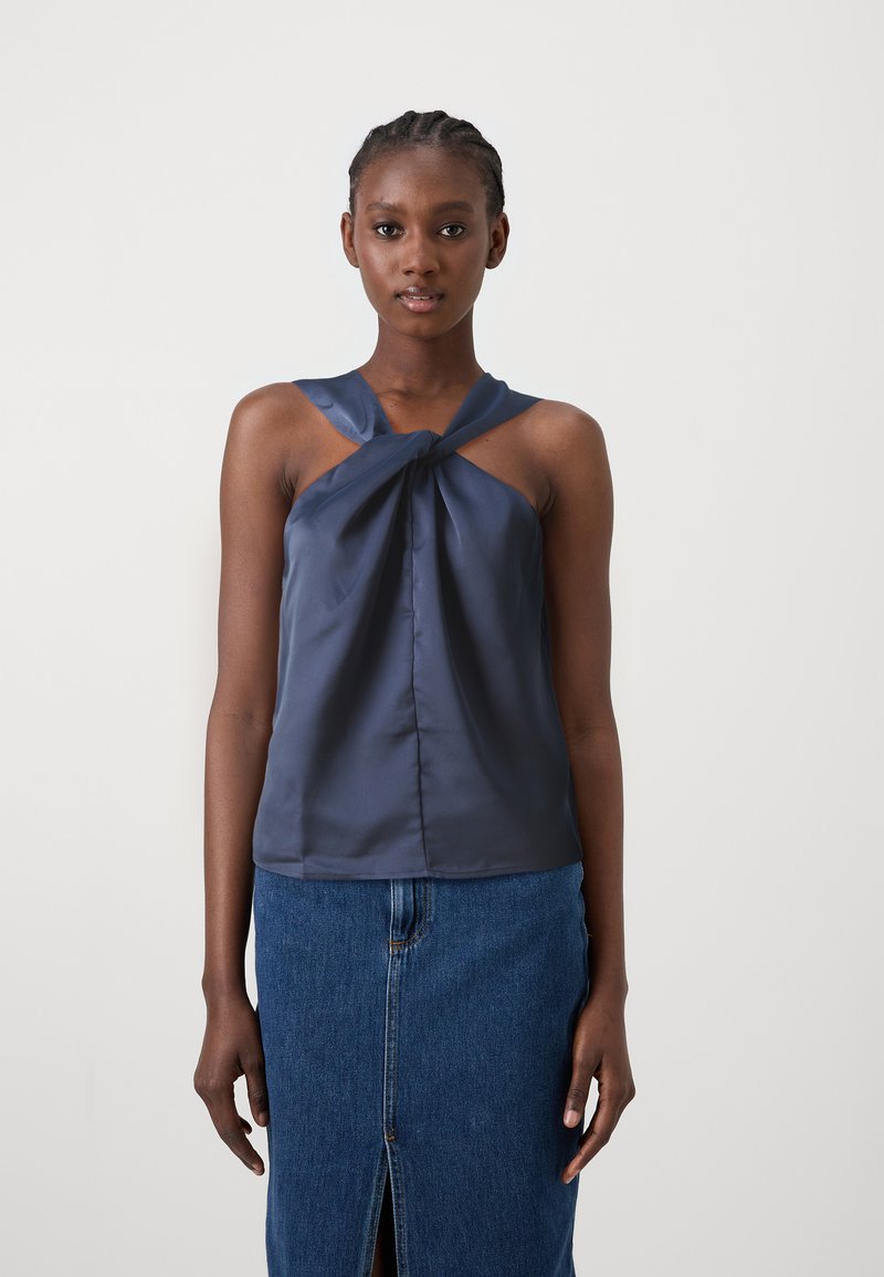 Marine satin uten ermer topp med vridd frontdetalj, kombinert med en jeansskjørt med frontsplitt og en tettsittende, rett design.