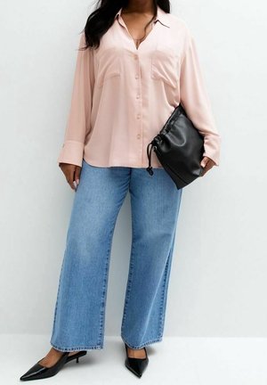 Light pink button-up shirt with two chest pockets, paired with wide-leg blue denim jeans. Black drawstring bag and pointed heels complete the look.