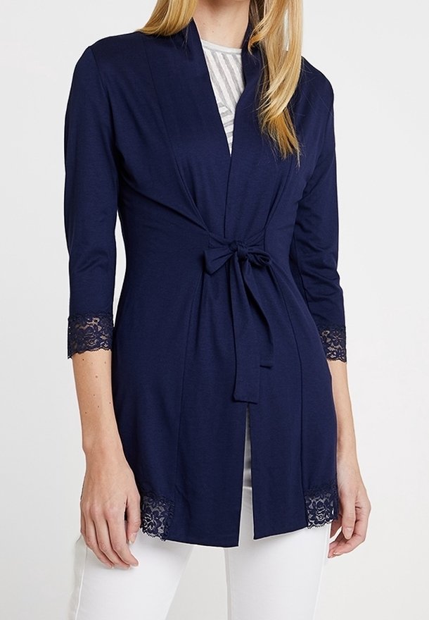 Mörkblå omslagströja med trekvartslånga ärmar, band i midjan, spetsdetaljer på ärmar och fåll, mjukt tyg, öppen framsida.