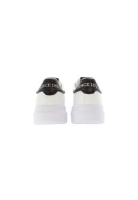 Sneaker bianchi con un tallone nero testurizzato che presenta la scritta "SINCE 1890" in bianco. Suola spessa bianca con una finitura liscia.