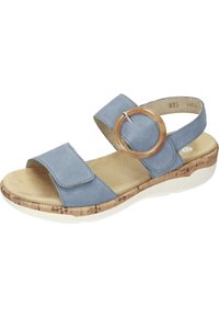 Sandale bleue en daim avec deux larges brides, un accent en bois circulaire et une semelle en liège texturé et blanche pour le confort.