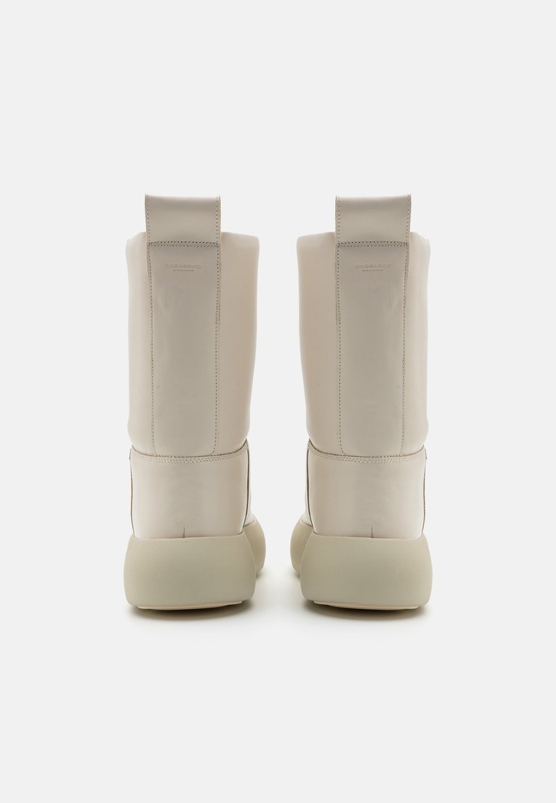 Stivaletti alla caviglia in pelle crema con una forma strutturata, suola in gomma spessa e linguetta posteriore rinforzata per una facile vestibilità. Design minimalista con cuciture discreti.