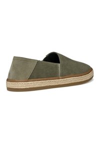 Zapatos de lona verde oliva sin cordones, con parte superior de lona, suela de yute trenzado y base de goma para tracción. Punta redondeada y lados abiertos para transpirabilidad.