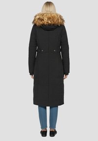 Długi czarny płaszcz z kapturkiem z sztucznego futra, pikowanym wzorem i bocznymi kieszeniami. Posiada taliowany krój z ozdobnymi guzikami oraz długość do połowy uda.