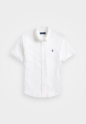Camisa de botones de manga corta blanca hecha de algodón. Presenta un cuello clásico, una sutil textura en el tejido y un logo azul en el pecho.