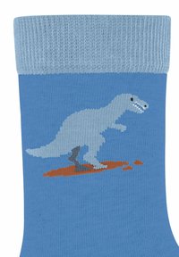 Niebieska skarpetka za kostkę z jasnoniebieskim ściągaczem; posiada szary wzór dinozaura na rdzawej łatce. Gładka tekstura, dzianina.