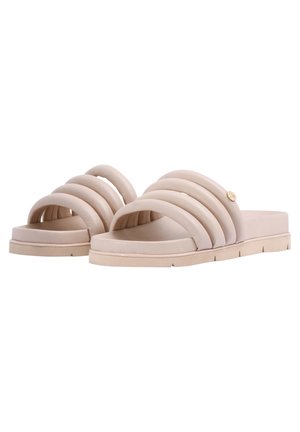 Beige slidesandal med tre polstrede, horisontale remme og en flad, tekstureret sål, vist fra en lav frontvinkel.