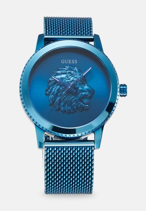 Montre en acier inoxydable bleu avec un lion embossé sur le cadran, bracelet en maille et accents bleus ; elle présente un boîtier rond et des marqueurs d'heure simples.