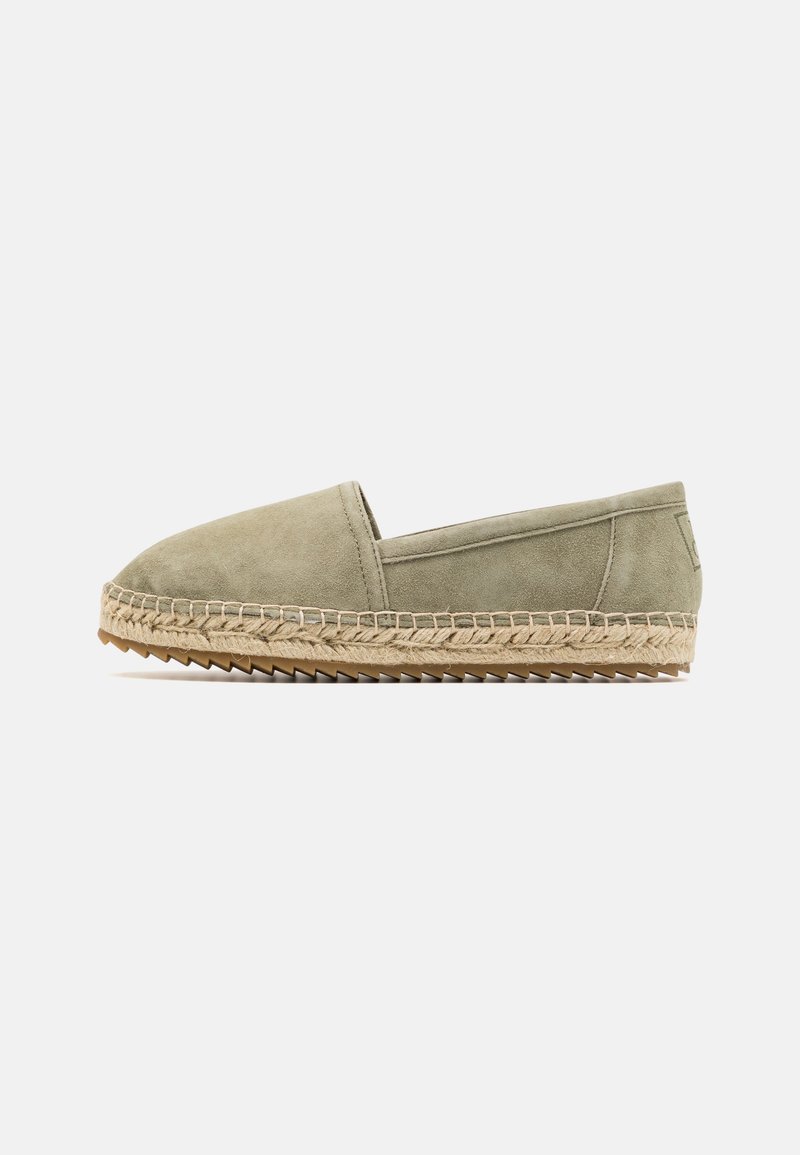 Espadrille plate en daim vert olive clair avec semelle intermédiaire en jute tressée et semelle extérieure en caoutchouc zigzag, style à enfiler, vue de profil latéral.