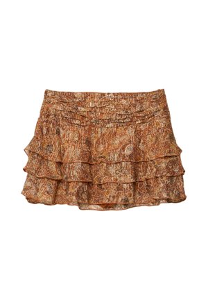 Jupe courte à plusieurs niveaux dans des tons d'orange et de marron, présentant un motif paisley et un tissu texturé. L'ourlet à volants ajoute de la dimension.