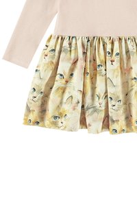 Långärmad klänning med en ribbad beige överdel och en volangkjol som har ett akvarelltryck av olika katter med blå ögon på en ljus bakgrund.