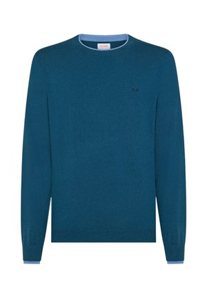Maglione a maniche lunghe blu teal con colletto interno azzurro e piccolo logo ricamato "ΔX" in nero sul lato sinistro del torace.