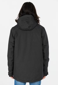 Svart, huva jacka med en matt finish, med rak skärning och knappade ärmslut. Bakvyn visar en sömlös design med minimala accent.