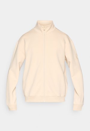 Világos bézs zipzáras dzseki magas gallérral, bordázott mandzsettákkal és sima textúrával. Minimalista dizájnt kínál minták nélkül.