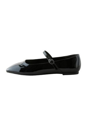 Zapato plano de charol negro con punta afilada, correa al tobillo y detalle de hebilla redonda. Textura suave, diseño de tacón bajo.
