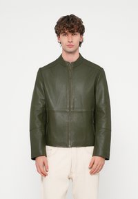 Olijfgroene leren jas met een opstaande kraag, ritssluiting aan de voorkant, zijzakken en gestructureerde panelen voor een moderne pasvorm.