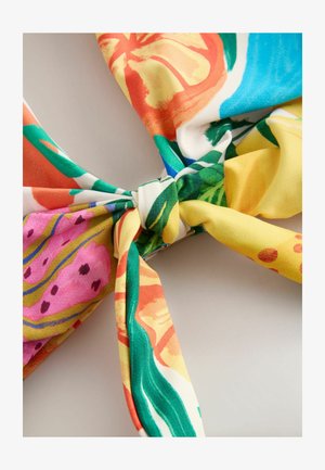 Barevná látková šála s květinovým vzorem v oranžové, růžové, zelené a žluté barvě. Uprostřed je uvázaný uzel, hladká textura.